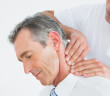 Close-up of a male chiropractor massaging patients neck over whi